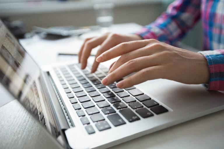 a person typing on a laptop computer