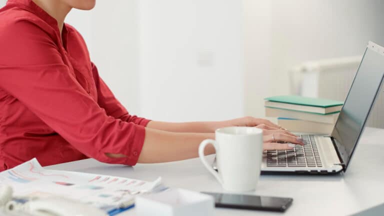 a woman sitting at a table with a laptop computer