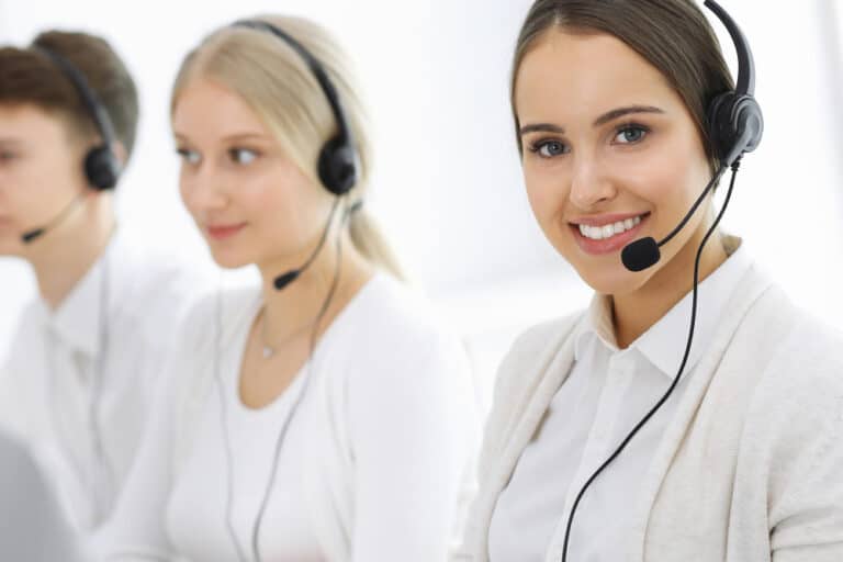 a woman wearing a headset smiles at the camera