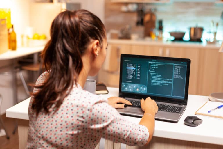 a woman sitting at a table with a laptop